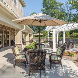 A cozy patio area featuring a table with an umbrella, surrounded by wicker chairs, perfect for outdoor relaxation.