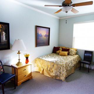 A cozy bedroom with a bed, nightstand, and decorative artwork on the walls.