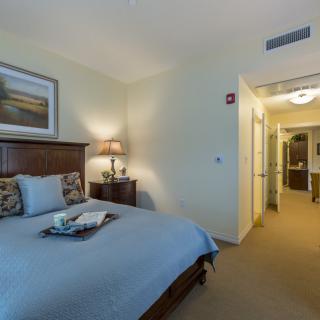 A cozy bedroom interior with a neatly made bed and soft lighting.