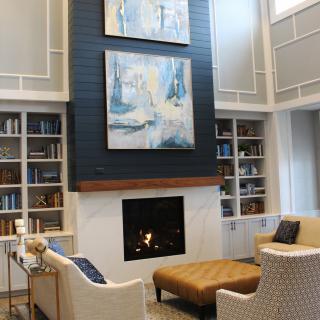 A cozy living room with a modern fireplace, abstract artwork, and built-in bookshelves.