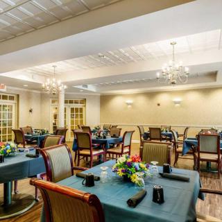 Elegant dining room with neatly arranged tables and chandeliers.