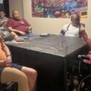 A group of people casually gathered around a table indoors.