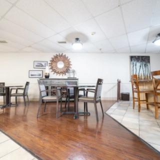 A modern dining area with tables and chairs arranged on a wooden floor.