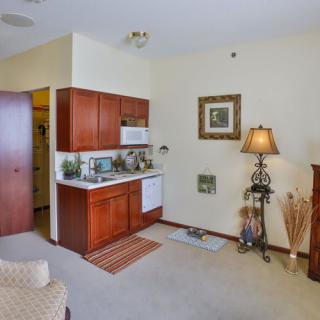 A cozy apartment with a small kitchenette and warm decor.