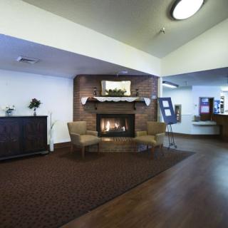 A cozy hotel lobby with comfortable chairs and a warm fireplace.