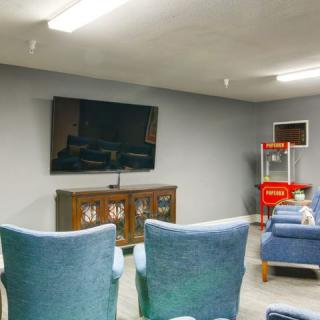 A cozy home theater setup with a large TV and comfortable seating.