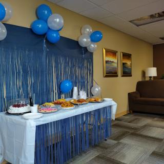 A festive setup featuring a table adorned with treats and blue balloons, perfect for a celebration.