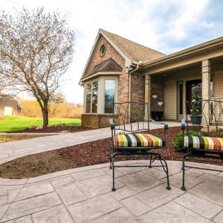 A suburban house with a landscaped patio and outdoor seating.