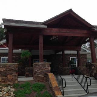 A building entrance featuring stone and wood architecture with stairs leading up to the entrance.
