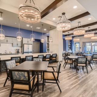 A modern dining area with elegant chandeliers and comfortable seating.