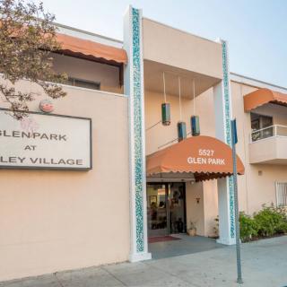 Entrance to a residential building with an orange awning and signage.