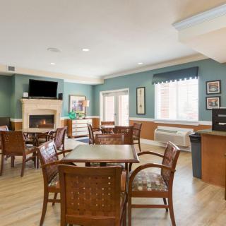 A cozy dining area featuring wooden furniture, a fireplace, and a television.