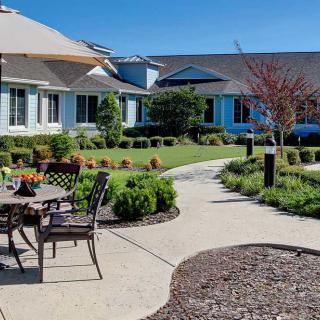 A beautifully landscaped residential garden with a patio and outdoor seating.