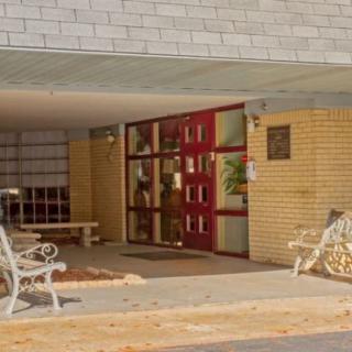 A building entrance with a red doorway and benches on either side.