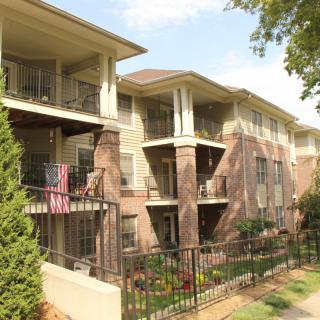 A multi-story apartment building with balconies and surrounding greenery.