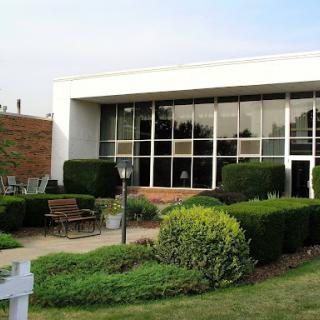 A contemporary building with large windows and well-maintained landscaping.
