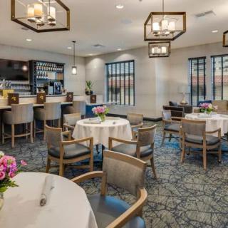 A cozy restaurant dining area with elegantly set tables and modern lighting.