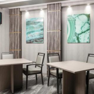 A modern conference room with tables, chairs, and abstract artwork on the walls.