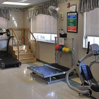 A rehabilitation room equipped with treadmills, an exercise bike, and other physical therapy equipment.