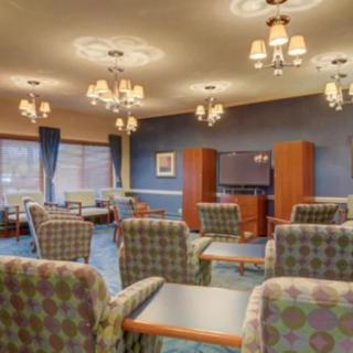 A well-lit communal living area with comfortable seating and a large television.