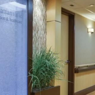 A modern office hallway with a plant and soft lighting.