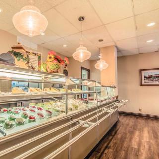 A cozy bakery interior showcasing a variety of desserts in a well-lit display case.