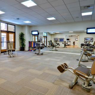 A modern gym with exercise equipment and mirrors.