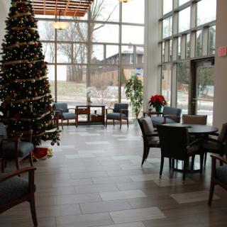 A cozy and modern lobby decorated for the holiday season, featuring a beautifully adorned Christmas tree.
