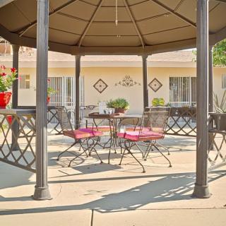 A cozy outdoor gazebo with metal furniture on a sunny patio.