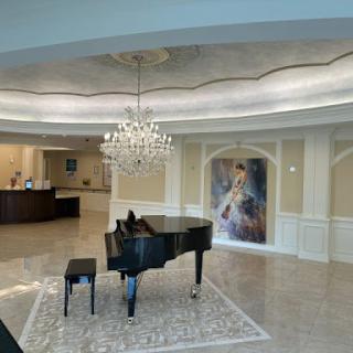 A luxurious lobby featuring a grand piano and an elegant chandelier.