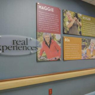 Hospital hallway with posters showcasing patient testimonials.