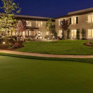 A beautifully lit house and garden at night.