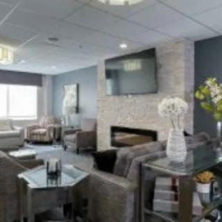 A modern living room with a fireplace and television, featuring comfortable seating and elegant decor.