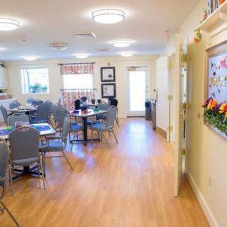 A bright and welcoming community dining area with tables and chairs arranged for guests.