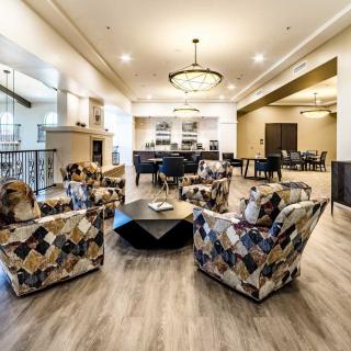 A spacious and elegantly designed living room with modern furniture and chandeliers.