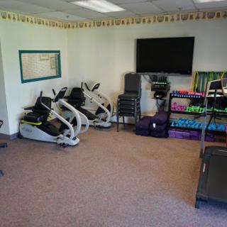 A well-equipped fitness room featuring exercise machines and weights.