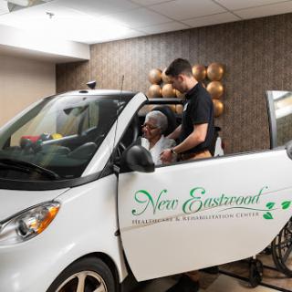 A caregiver assists an elderly person inside a specially designed healthcare vehicle.