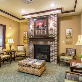 A cozy living room with a brick fireplace, surrounded by comfortable seating and warm lighting.