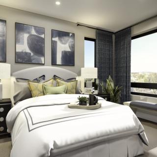 A stylish and modern bedroom with elegant decor, featuring a neatly made bed, abstract artwork, and ample natural light.