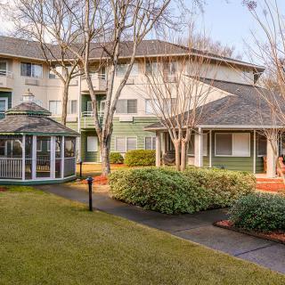 A well-maintained building with a gazebo surrounded by trees and landscaped gardens.