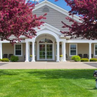 A beautiful residential building surrounded by vibrant trees and well-maintained lawn.