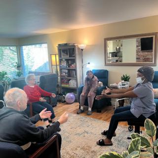 Seniors participating in a group exercise session in a cozy indoor setting.