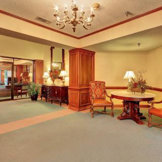 A warmly decorated hotel lobby with traditional furnishings and a chandelier.