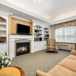 A cozy living room with a fireplace, television, and bookshelves.