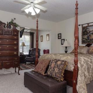 A cozy bedroom featuring a four-poster bed, a wooden dresser, and elegant decor.