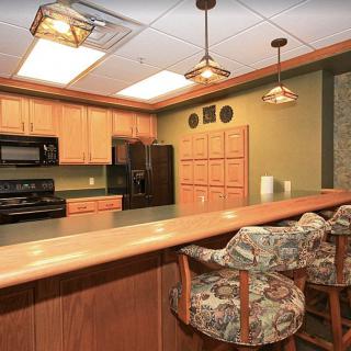 A warm and inviting kitchen with wooden cabinetry and decorative hanging lights.