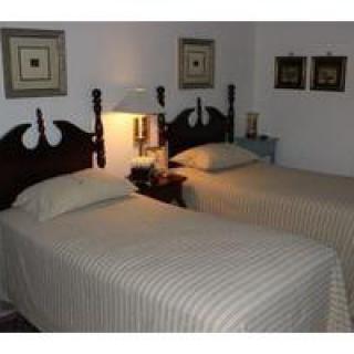 A cozy bedroom featuring twin beds with wooden headboards and decorative elements.