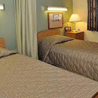 A cozy hotel room with twin beds and a nightstand.