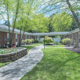 A serene residential courtyard with a winding pathway and lush greenery.