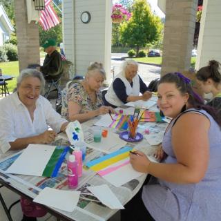 A group of people enjoying an outdoor painting activity together.